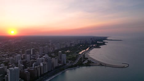 sunset above chicago usa and lake michigan, cinematic aerial view of cityscape and shoreline