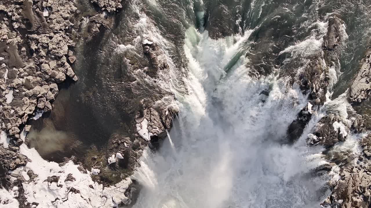 Stunning aerial view of Selfoss waterfall in Iceland during winter, icy terrain with river flow through volcanic rocks.