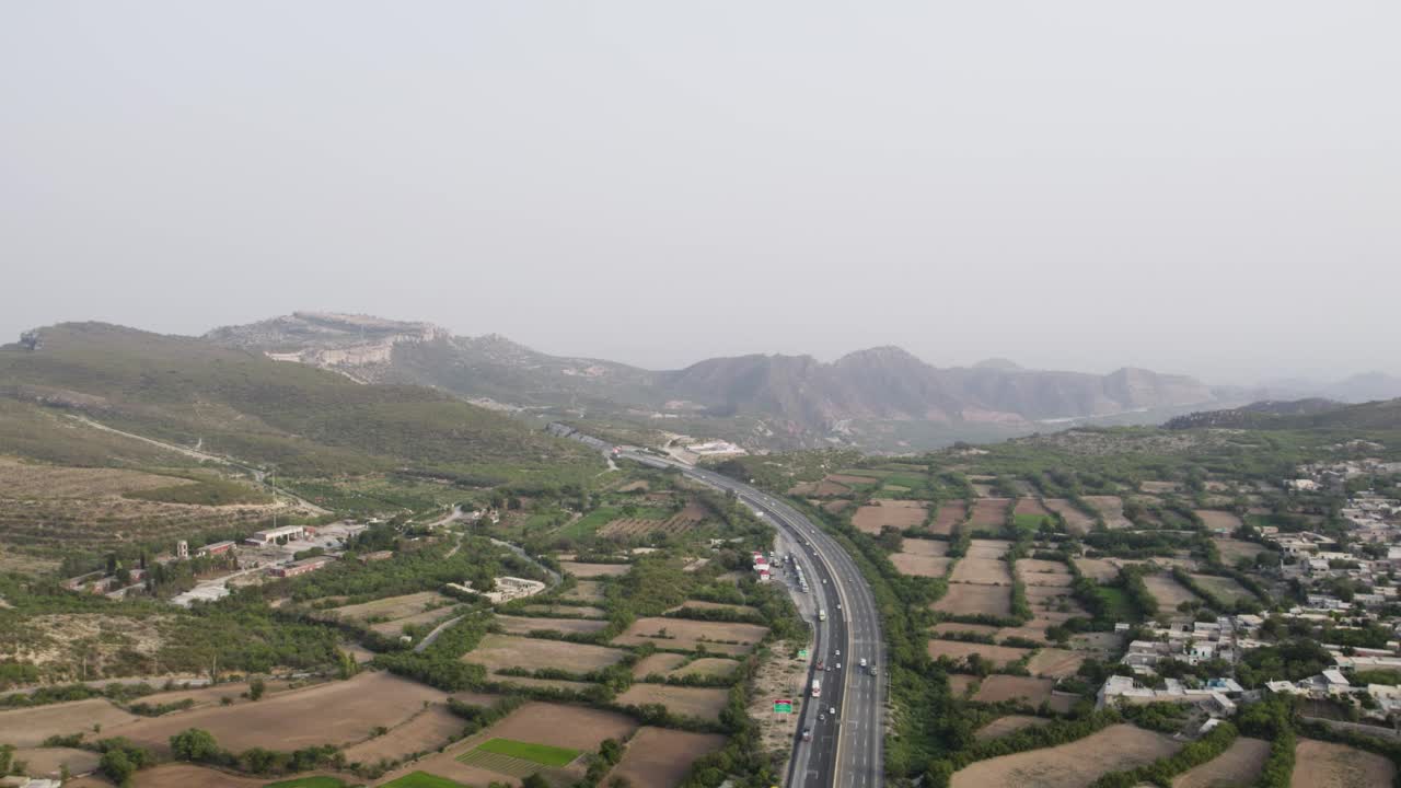 vehicles moving along Pakistan’s motorway, showing multiple lanes and surrounding landscape. Pakistan