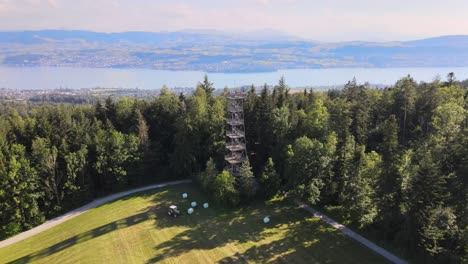 aerial drone shot flying away showing the pfannenstiel observation tower and revealing lake zürich in the background