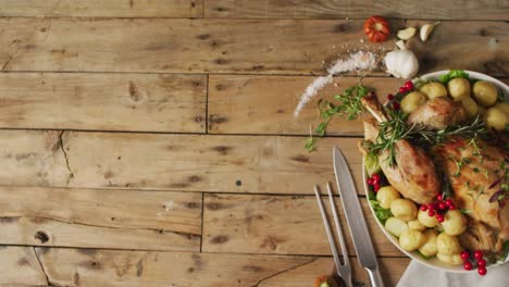 video of tray with roasted turkey, potatoes and cutlery on wooden surface