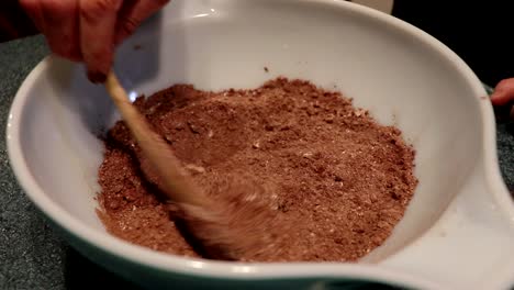 a person mixes ingredients to make a cake