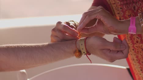 a woman tying a string around someone's wrist