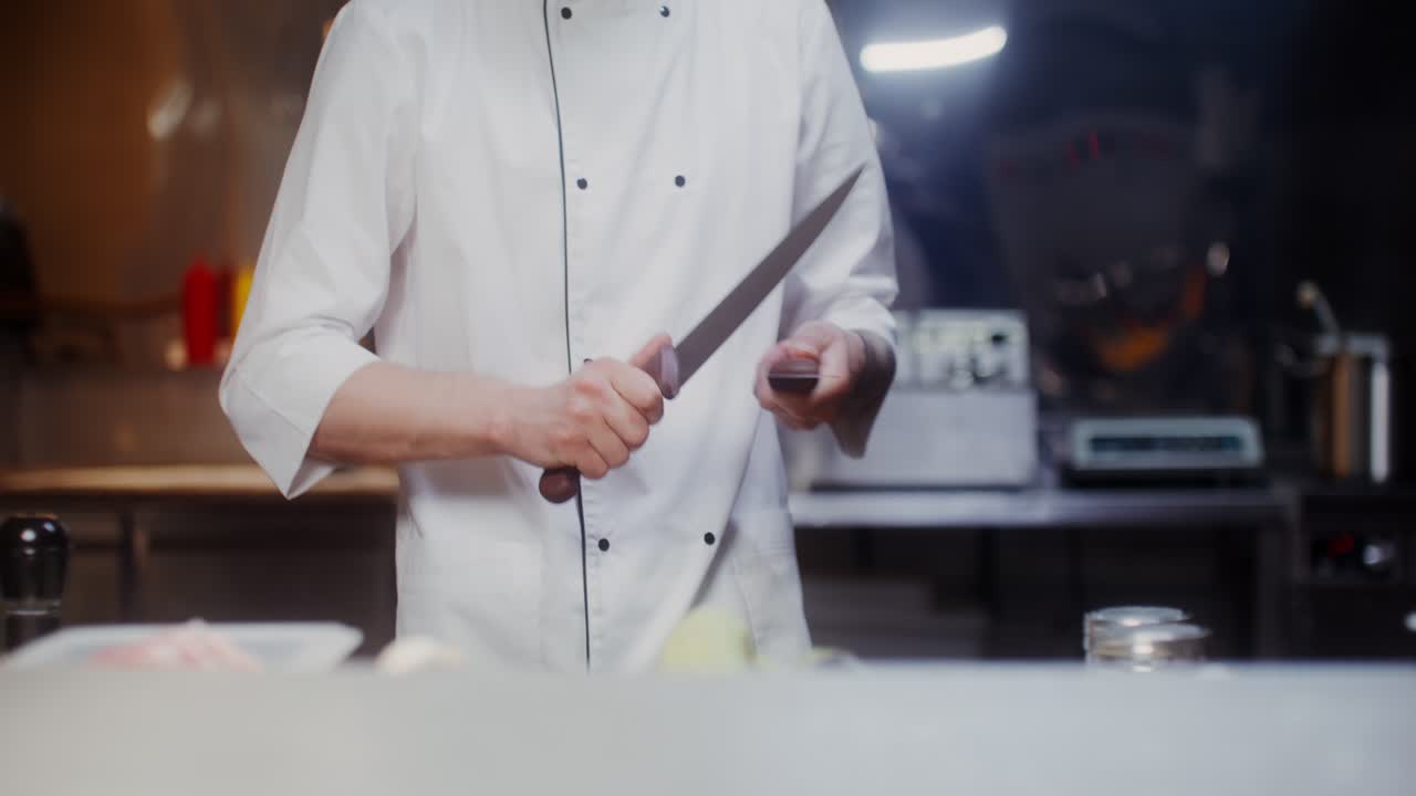 chef afilando un cuchillo en la cocina de un restaurante