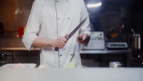 chef sharpening a knife in a restaurant kitchen