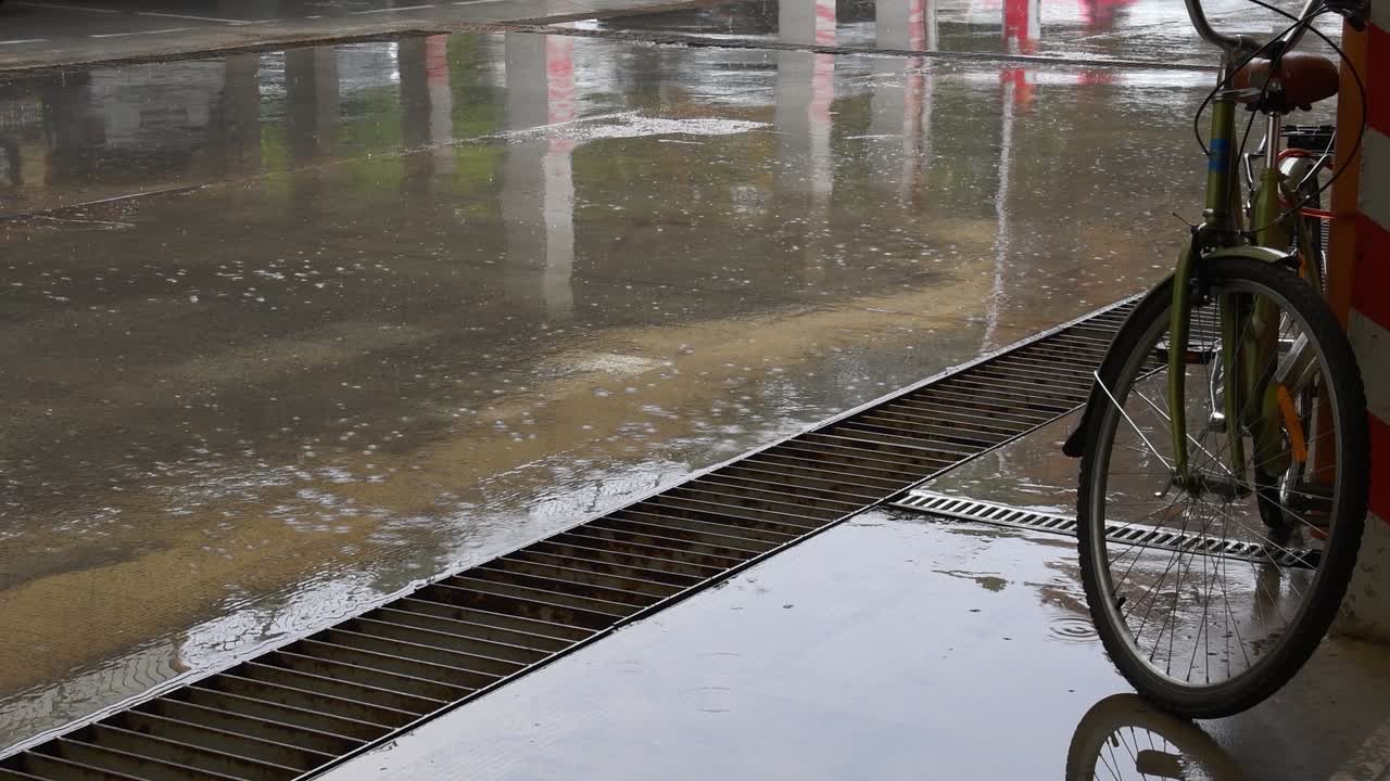 자전거 바와 함께 도시 주차장의 시멘트 바닥에 웅이로 비를 뿌리십시오.