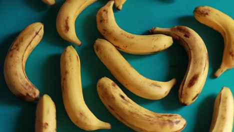 Eine-Makroaufnahme-Reifer-Gelber-Bio-Bananen,-Die-Sich-Vor-Grünem-Hintergrund-Drehen