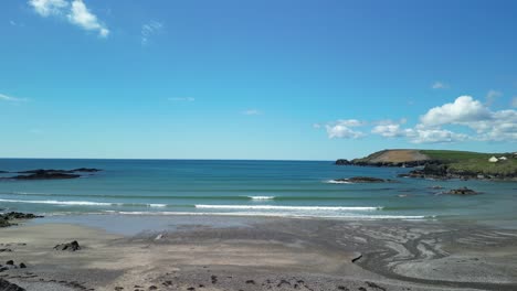 Día-Azul-Soleado-En-Mayo-En-La-Playa-De-Owenachincha-En-West-Cork,-Imágenes-Aéreas-Sobre-Aguas-Tranquilas-Del-Océano-Atlántico