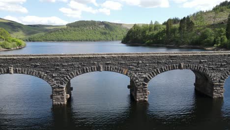 Garreg-Ddu-Dam-Elan-Valley-Wales-low-drone-shot-rising-over-dam,-bridge