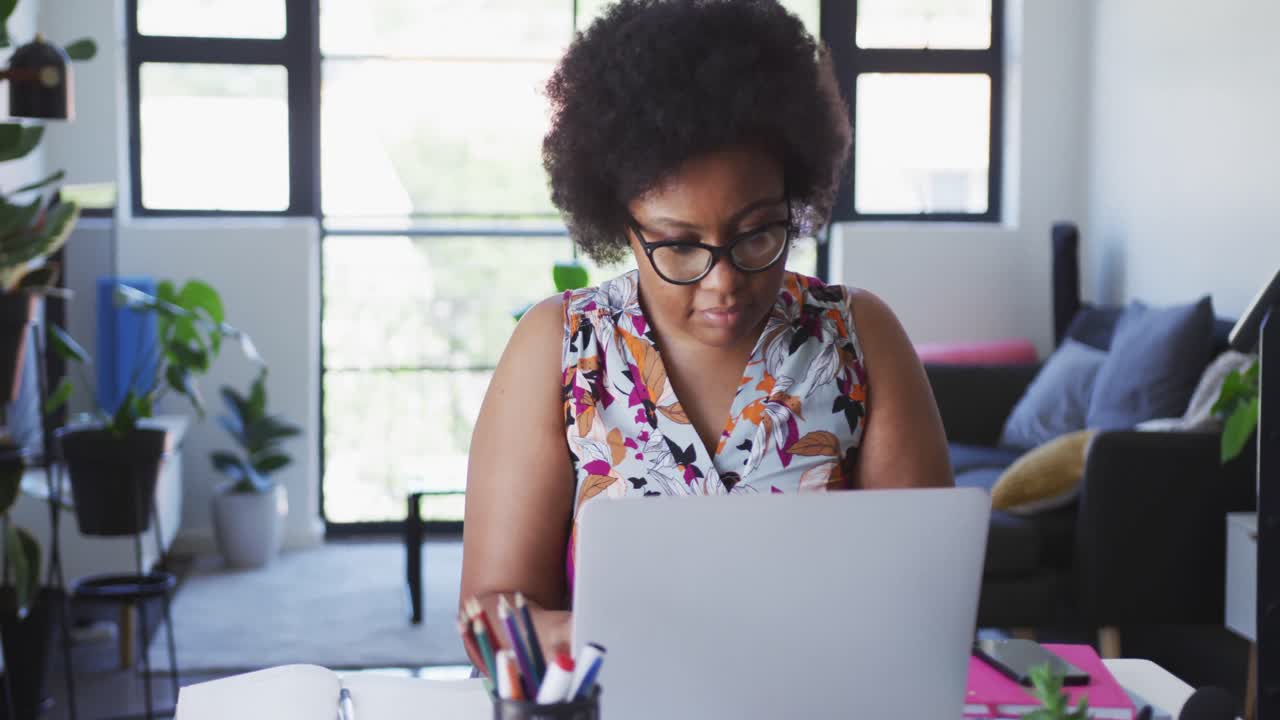 African american female plus size vlogger sitting using laptop