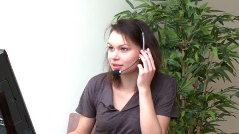 Fröhliche-Frau-Mit-Headset-Bei-Der-Arbeit-Am-Computer