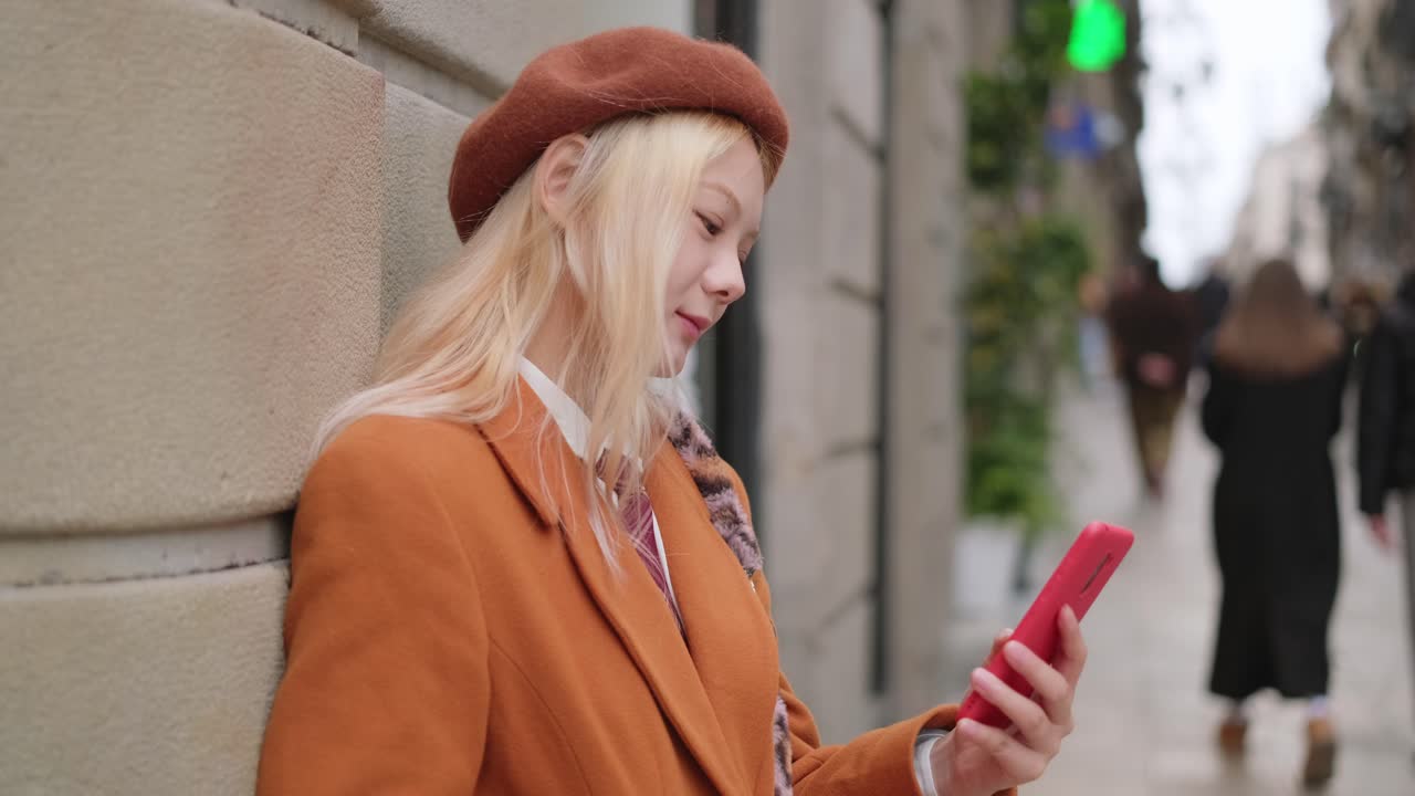 도시 거리에서 스마트폰을 사용하는 여성