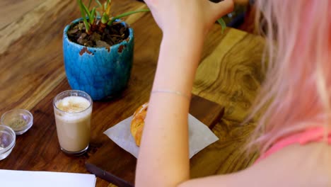 Woman-photographing-coffee-and-snacks-in-cafe-4k