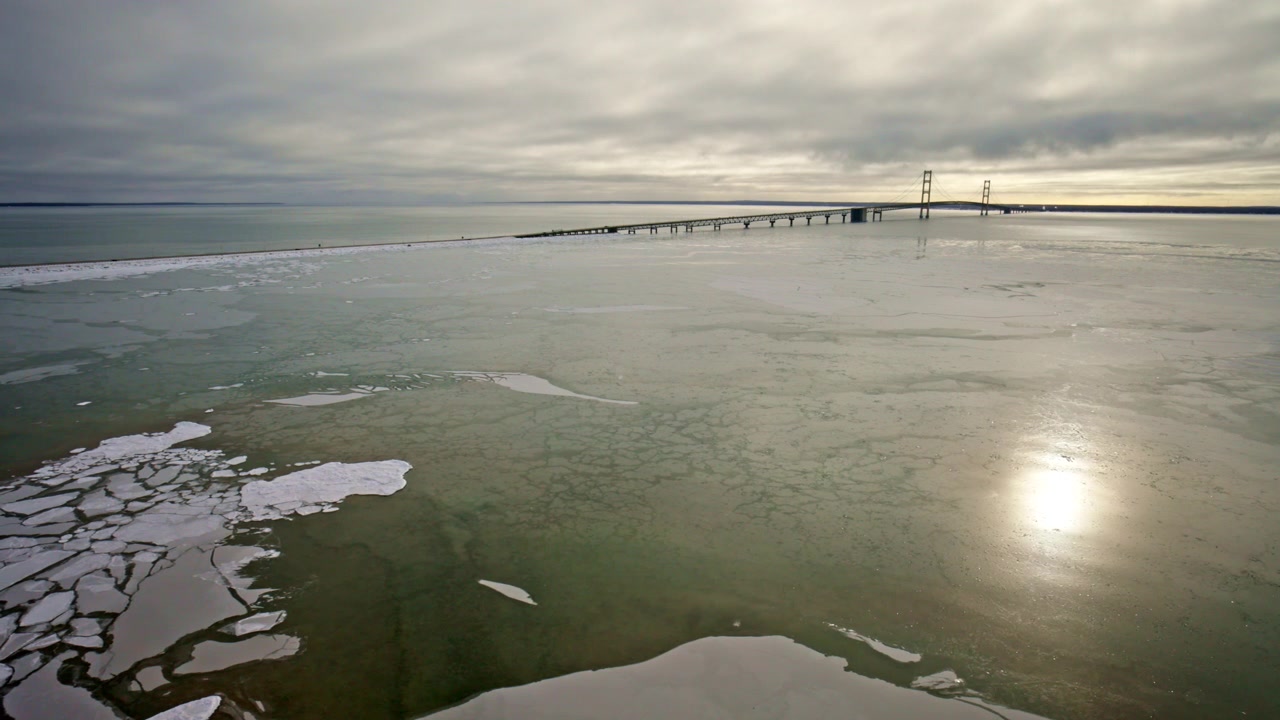 Luftopptak av Mackinac Bridge innrammet av frossen is og snø i en Michigan-vinter.