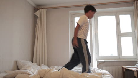 el adolescente salta en la cama