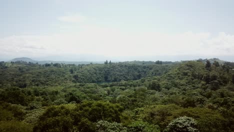 Vista-Aérea-Del-Lago-Del-Cráter-En-Medio-De-Frondosos-Bosques-En-El-Oeste-De-Uganda,-África