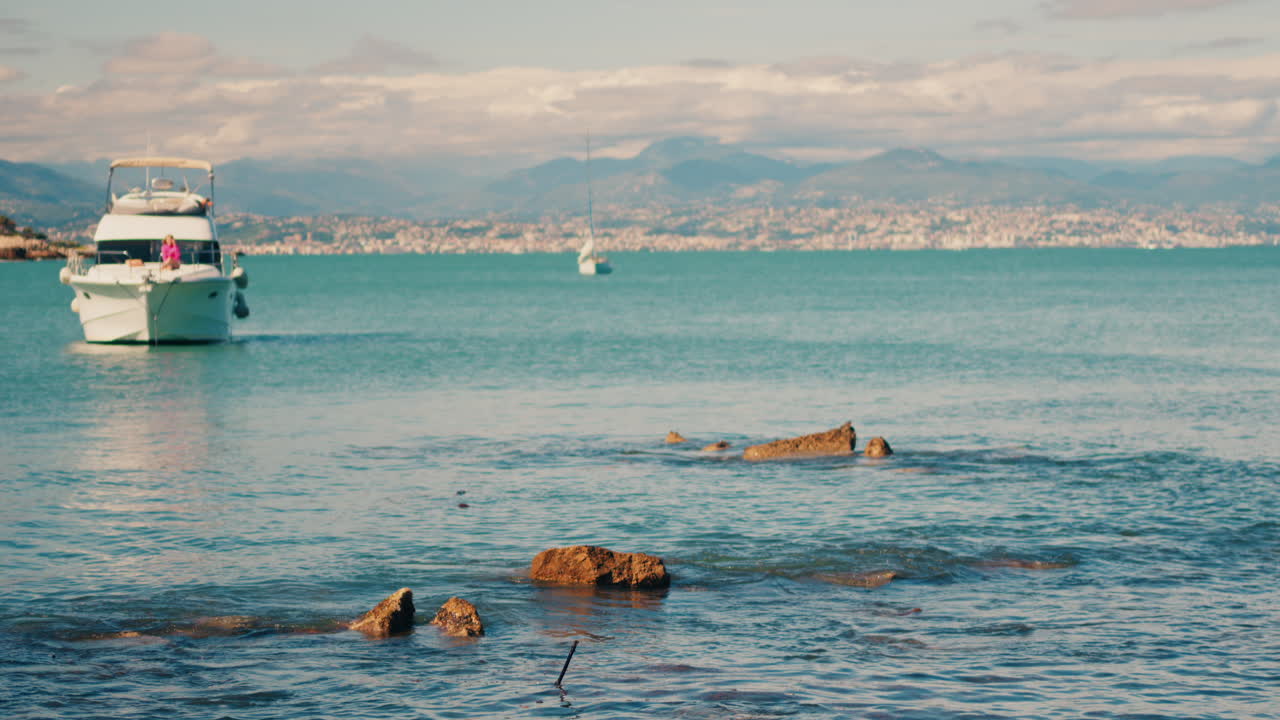 Boat floating on the sea with the town of Bandol, France on the background