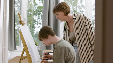 mother and daughter painting on canvas