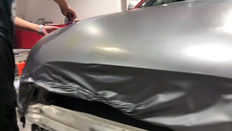 men foiling and wrapping a car