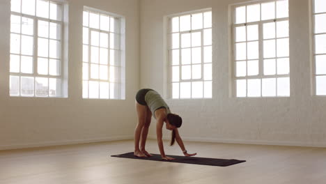 healthy yoga woman practicing downward-facing dog pose enjoying fitness lifestyle exercising in workout studio training on exercise mat at sunrise