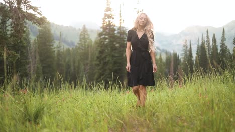 beautiful young blonde woman walking in serene utah mountain forest trail