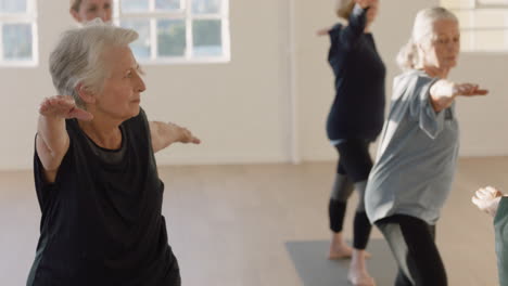 Yoga-Kurs,-Schöne-ältere-Frau,-Die-Einen-Gesunden-Lebensstil-übt,-Krieger-Pose-übt-Und-Gruppenfitness-Workout-Im-Studio-Genießt