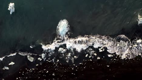 vista de arriba hacia abajo de los icebergs en la playa de diamantes en islandia - disparo de drones