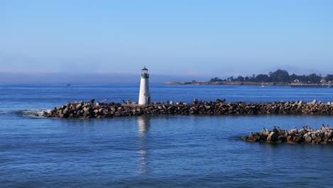walton lighthouse monterey bay santa cruz california usa aerial drone scenic landscape deep blue pacific ocean seagull pelican birds marina harbor jetty morning blue sky mist fog circle right parallax