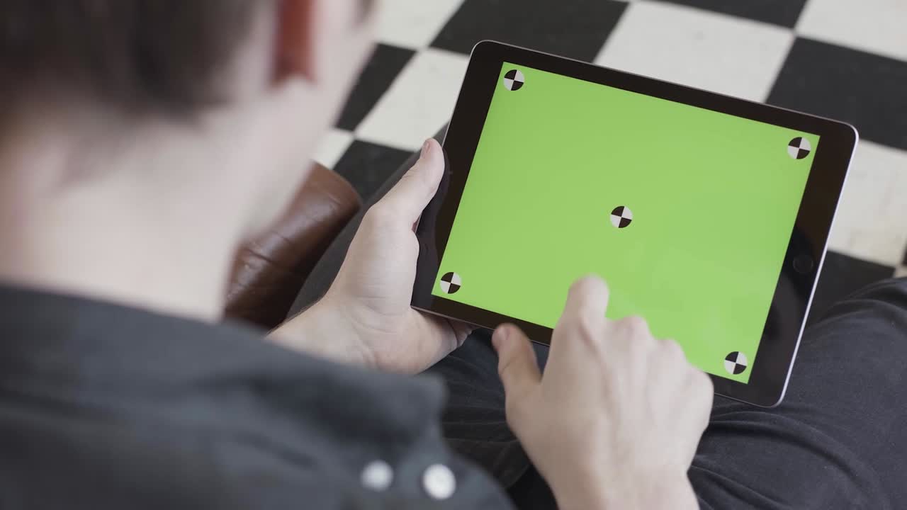 persona que utiliza una tableta con una pantalla verde