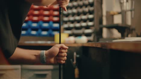 male hands press golf club shaft down on ground for custom fitting in workshop in slow motion