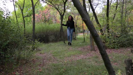 female model is walking through a forest with trees in slow motion