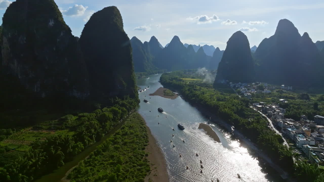 Luftfoto, der følger Li-flodens turistbåde, der sejler mellem bjerge i Kina.