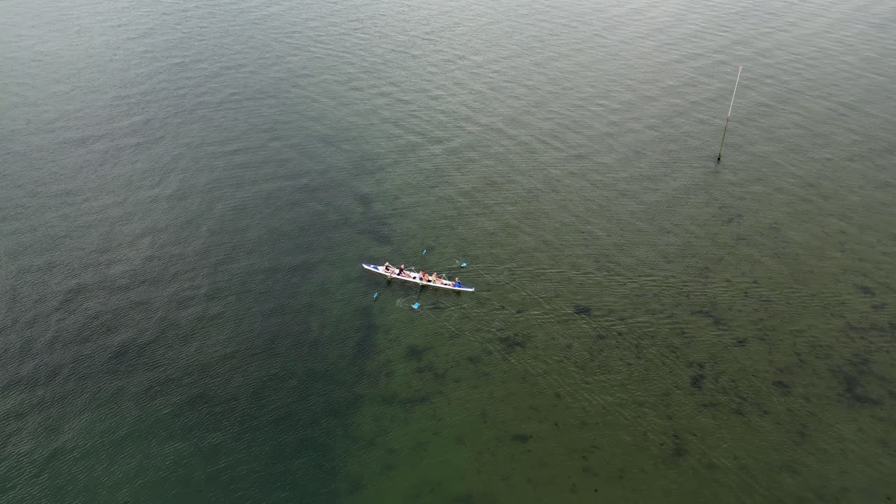 Rowers rowing on the open sea with no waves