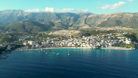 Pequeña-Ciudad-Costera-A-Orillas-Del-Mar-En-Albania-Con-Montañas-Al-Fondo