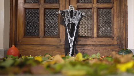 halloween home door decoration with autumn foliage moved by the wind