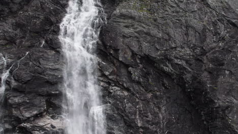 Toma-Aérea-Ajustada-De-La-Cascada-Stigfossen-En-Noruega-Mientras-Se-Estrella-Contra-El-Acantilado-Salvaje-Y-Escarpado.