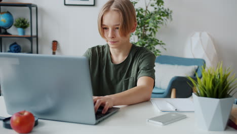niño adolescente estudiando en la computadora portátil en casa
