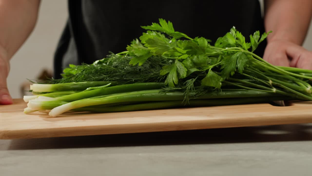 Cutting fresh green onions on a cutting board, close up chef cooking green vegan salad.