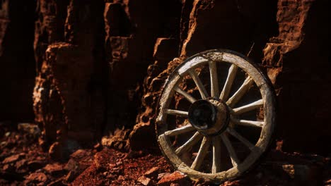 old wooden cart wheel on stone rocks