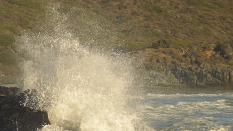 Olas-Del-Mar-Agitadas-Rompiendo-En-La-Costa-Rocosa-Creando-Un-Enorme-Rocío---Toma-Estática-Media