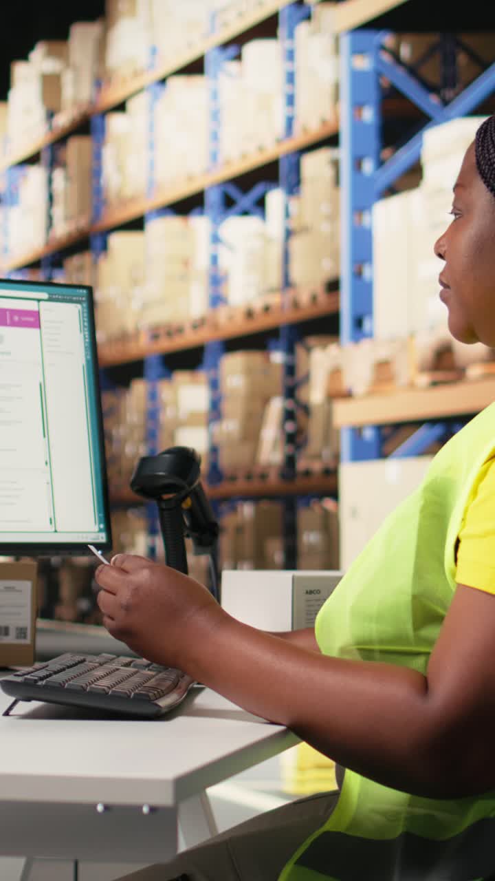 Vertical Video African american employee updating the order logistics software
