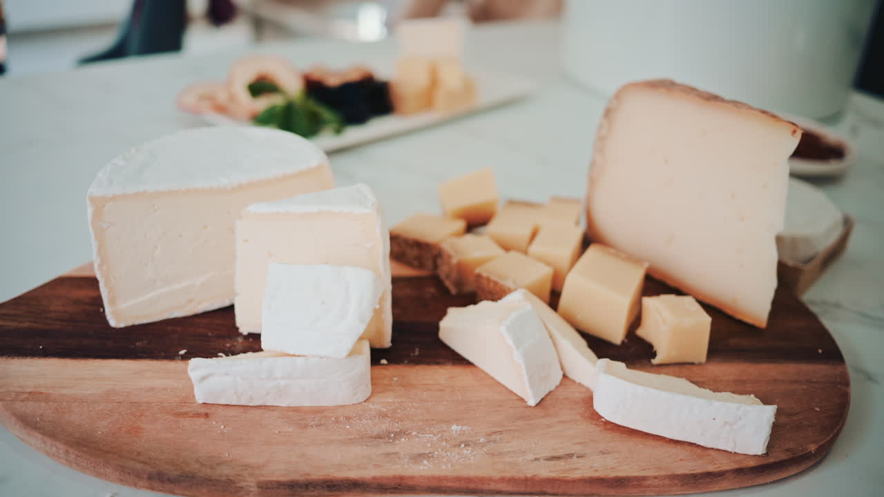 Selection of assorted cheeses arranged on a wooden board, captured in natural light