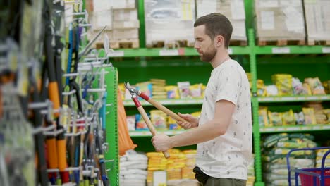 hombre comprando herramientas de jardinería en una tienda