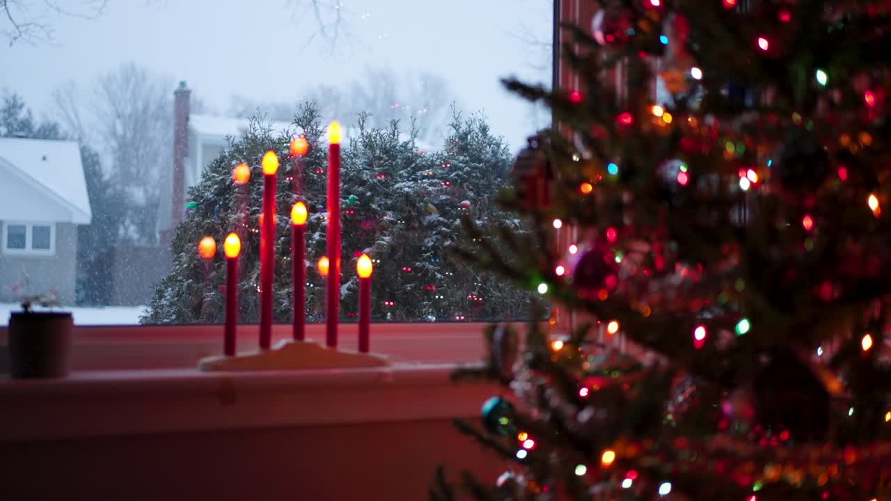 Christmas Tree and Led Candles with snowy window on Christmas eve, slow motion.