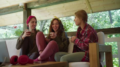 un grupo de hermosas chicas se sientan en un gazebo en la naturaleza, beben té y charlan. ambiente acogedor de comunicación en la naturaleza salida de fin de semana