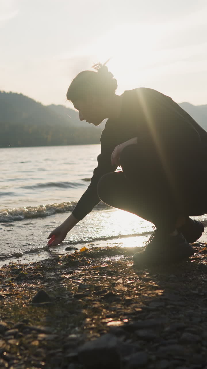 해가 지는 뒤에 호수의 물을 는 여자: 휴가 중 혼자있는 슬에서 휴식을 취하고 진정하려고 시도합니다.
