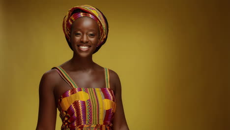 smiling african woman in traditional colorful headwrap and dress