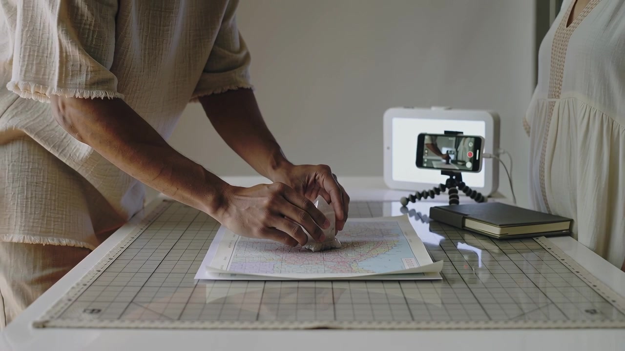 Person Using a Stamp on a Map for Content Creation