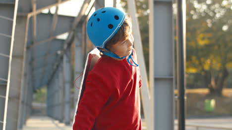 Süßer-Kleiner-Junge-Mit-Helm-Und-Rotem-Pullover-Mit-Flugzeugflügeln-Aus-Pappe,-Der-Vorgibt-Zu-Fliegen