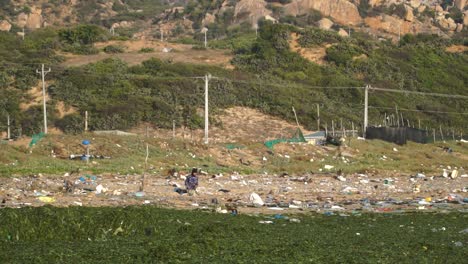 local vietnamese scavenging on the sea coast with littered waste